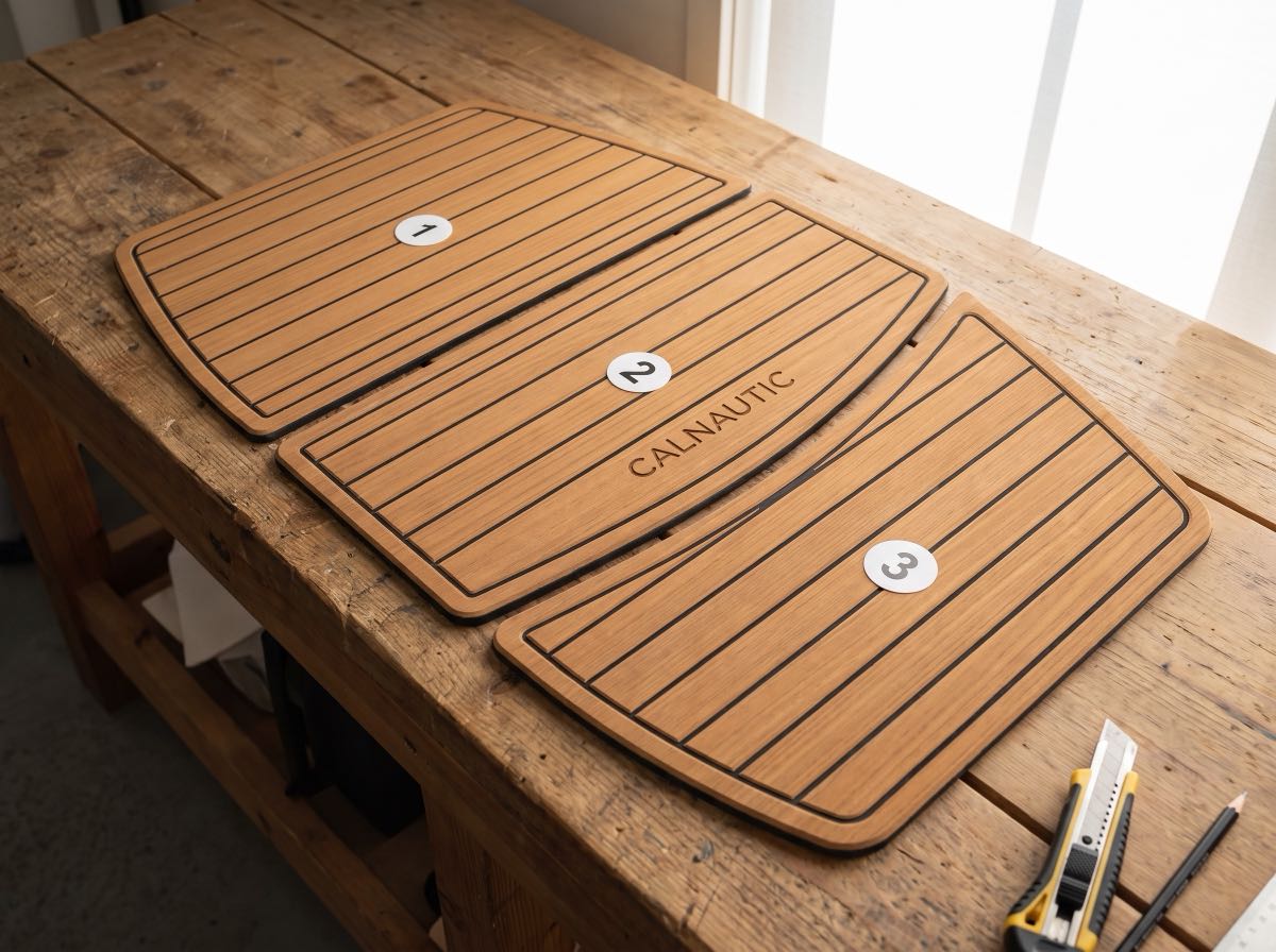 Piezas de espuma marina cortadas y numeradas para una moto de agua sobre la mesa del taller